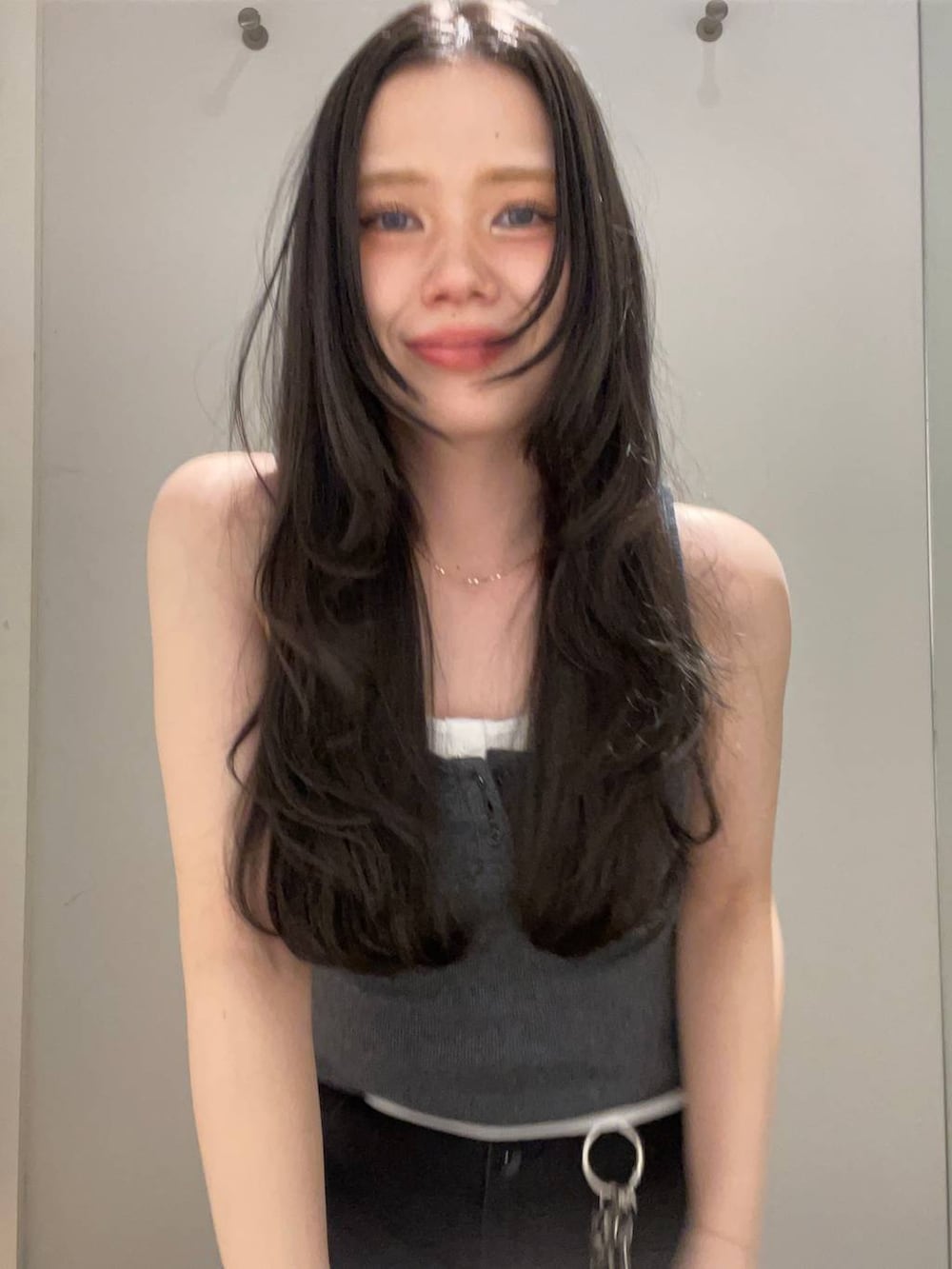 ブラック系のデニムパンツ、ホワイト系のタンクトップ、グレー系のタンクトップを着用したレディースの春コーディネートの4枚目の写真