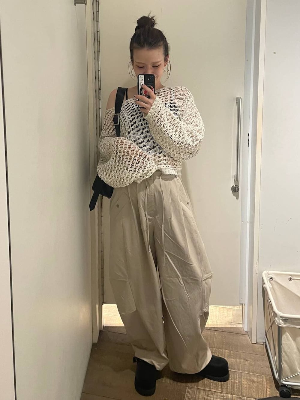 ブラック系のキャミソール、ブラック系のボストンバッグ、ブラック系のモカシン/デッキシューズを着用したレディースの春コーディネートの4枚目の写真