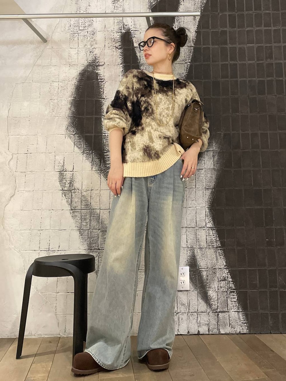 ブラウン系のニット/セーター、ブルー系のデニムパンツ、ブラウン系のボストンバッグを着用したレディースの冬コーディネートの2枚目の写真