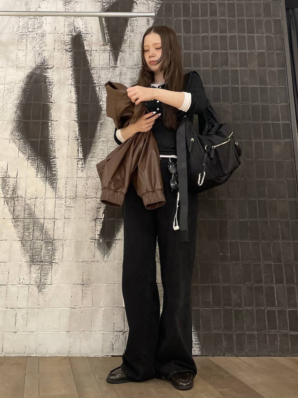 ブラック系のショルダーバッグ、ブラウン系のブルゾン、ブラック系のローファーを着用したレディースの春コーディネートの6枚目の写真