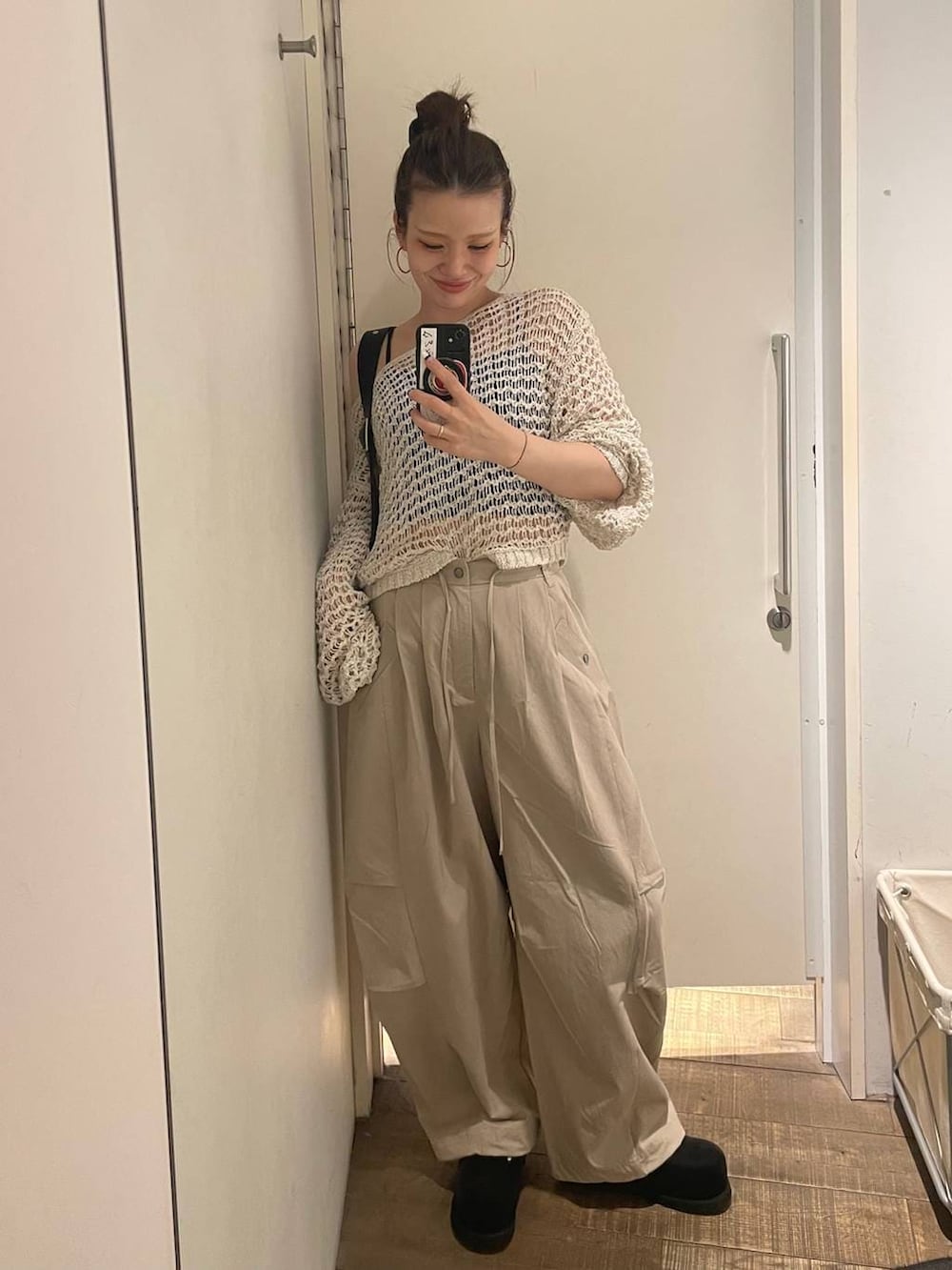 ブラック系のキャミソール、ブラック系のボストンバッグ、ブラック系のモカシン/デッキシューズを着用したレディースの春コーディネートの6枚目の写真