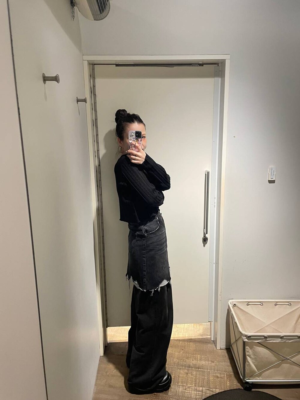 グレー系のデニムパンツ、ブラック系のカーディガン/ボレロ、ブラック系のデニムスカートを着用したレディースの秋コーディネートの5枚目の写真