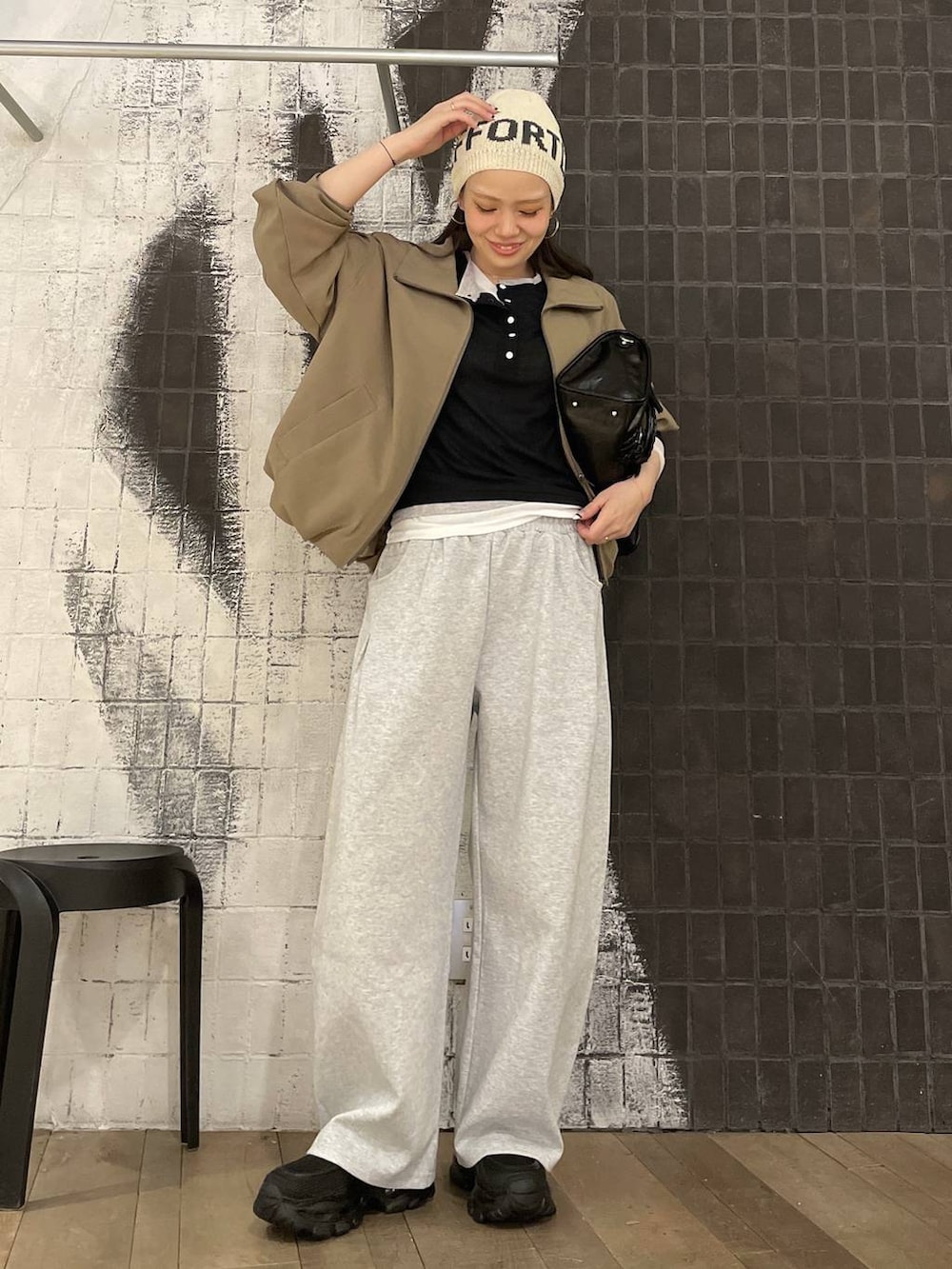 ブラック系のローファー、ブラウン系のボストンバッグ、グレー系のスウェットパンツを着用したレディースの春コーディネートの3枚目の写真