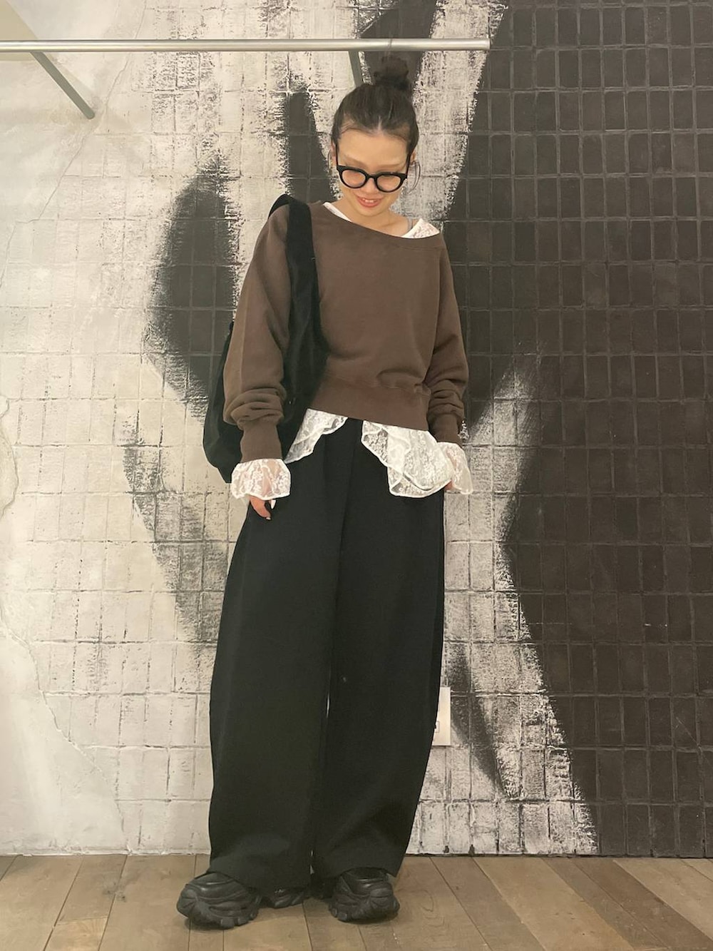 ブラック系のローファー、ブラウン系のスウェット、ブラック系のトートバッグを着用したレディースの冬コーディネートの2枚目の写真