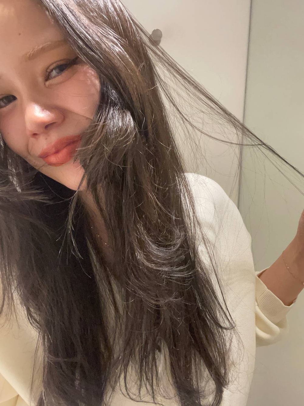 グレー系のデニムパンツ、ホワイト系のカーディガン/ボレロを着用したレディースの秋コーディネートの4枚目の写真