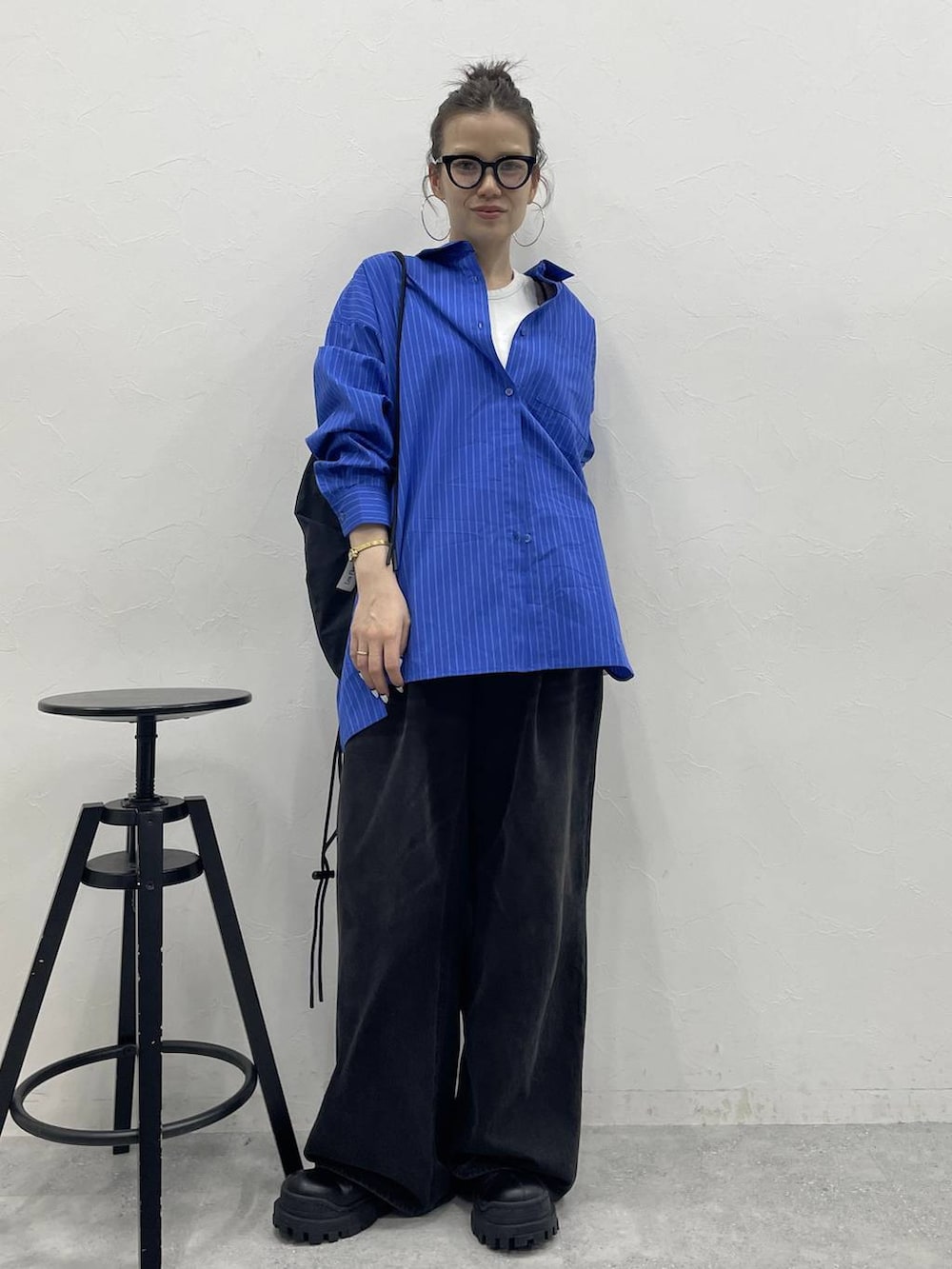 グレー系のデニムパンツ、ブラック系のブーツ、ブラック系のバックパック/リュックを着用したレディースの冬コーディネートの2枚目の写真