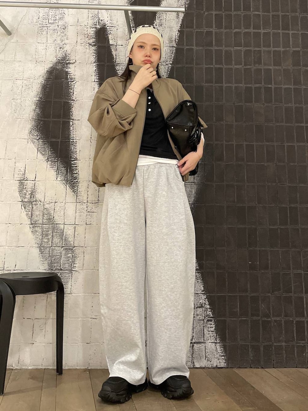 ブラック系のローファー、ブラウン系のボストンバッグ、グレー系のスウェットパンツを着用したレディースの春コーディネートの2枚目の写真