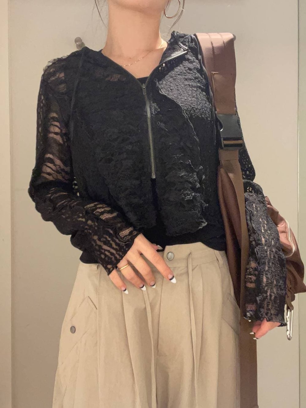 ブラウン系のショルダーバッグ、ブラック系のローファー、ベージュ系のその他パンツを着用したレディースの春コーディネートの3枚目の写真