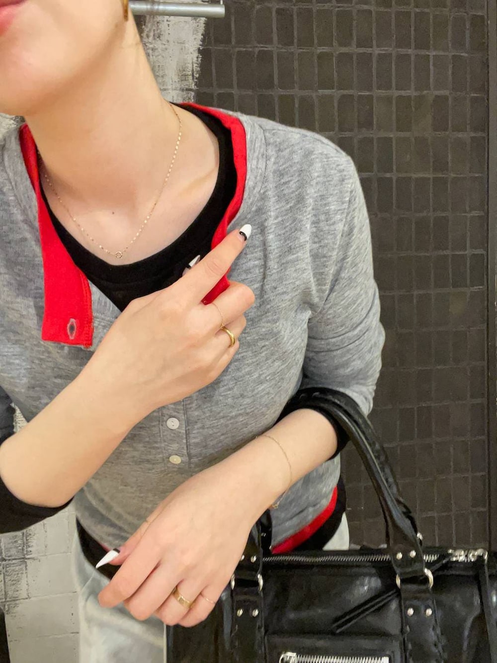 ブラック系のスニーカー、ブラック系のボストンバッグ、グレー系のスカートを着用したレディースの春コーディネートの4枚目の写真