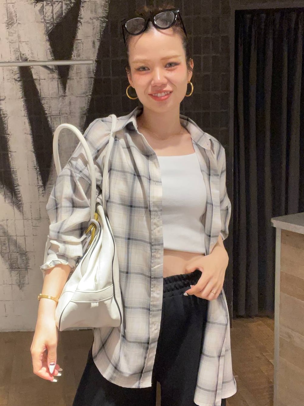 ホワイト系のシャツ/ブラウス、ブラック系のサンダル、ホワイト系のタンクトップを着用したレディースの夏コーディネートの5枚目の写真