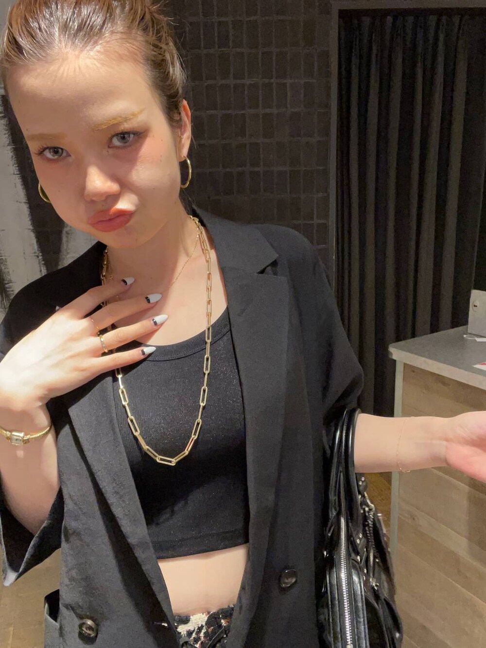 ブラック系のタンクトップ、ブラック系のボストンバッグ、ブラック系のサンダルを着用したレディースの夏コーディネートの7枚目の写真