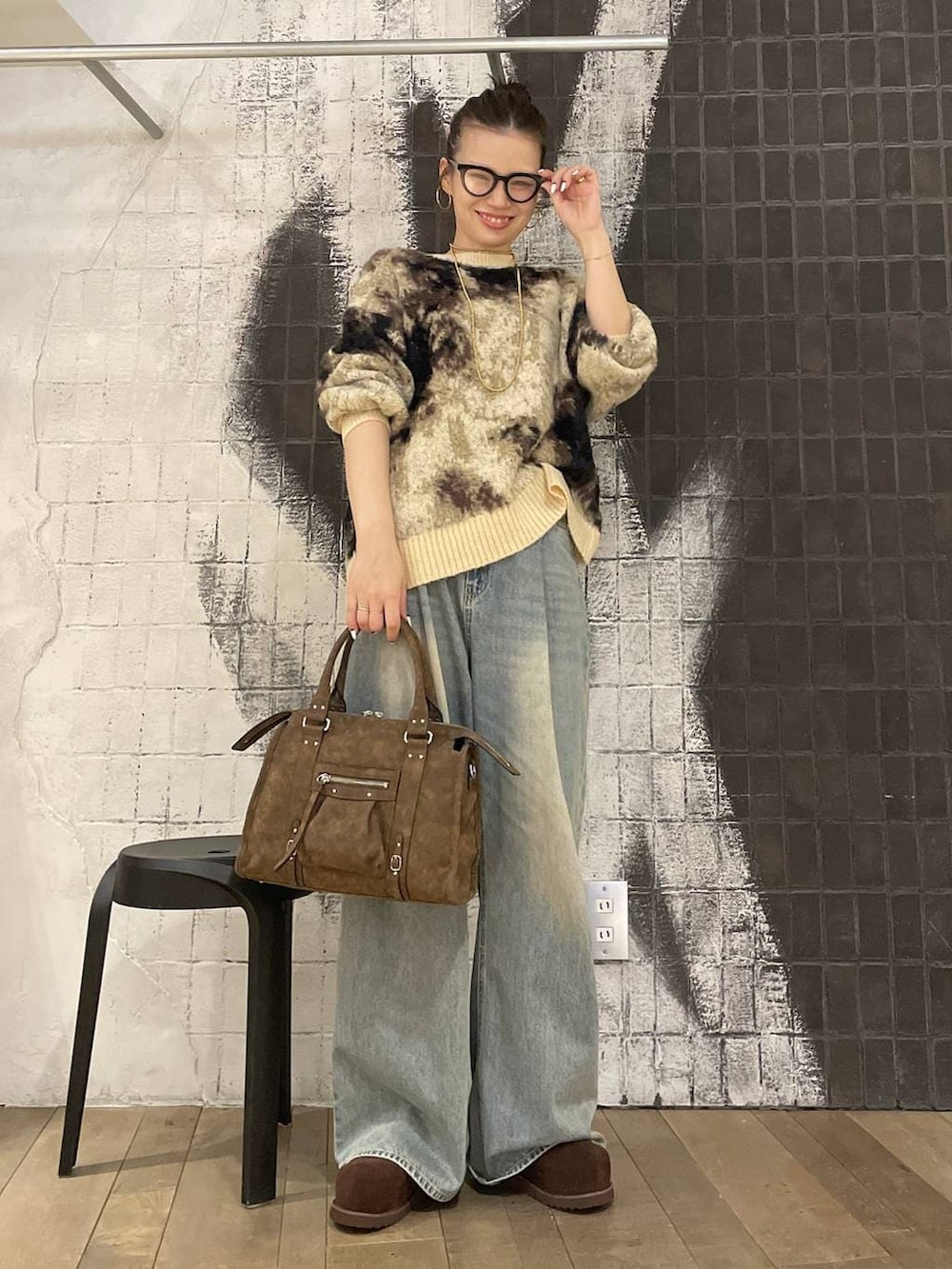 ブラウン系のニット/セーター、ブルー系のデニムパンツ、ブラウン系のボストンバッグを着用したレディースの冬コーディネートの7枚目の写真
