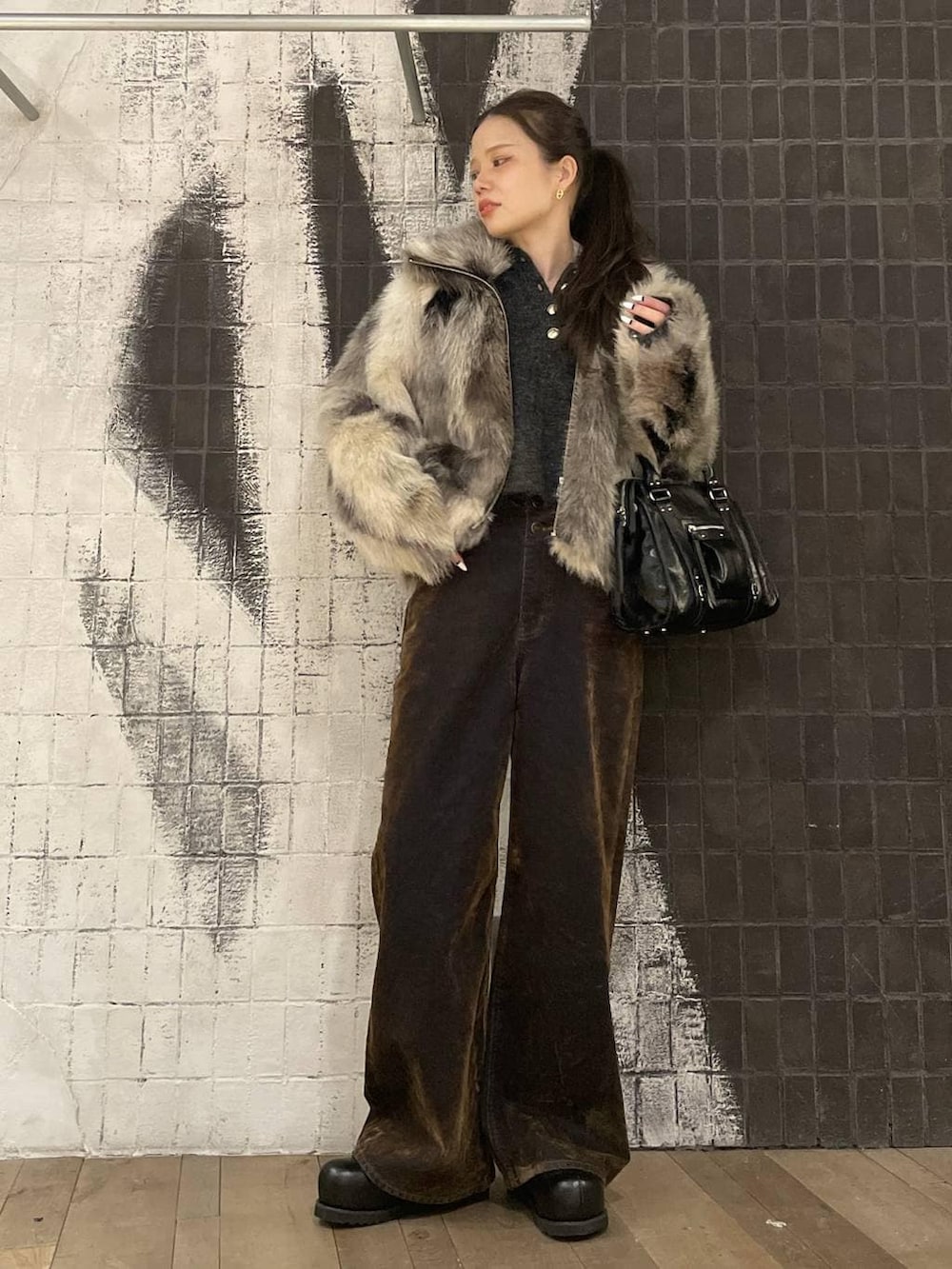 グレー系のブルゾン、ブラック系のその他シューズ、ブラウン系のデニムパンツを着用したレディースの冬コーディネートの4枚目の写真