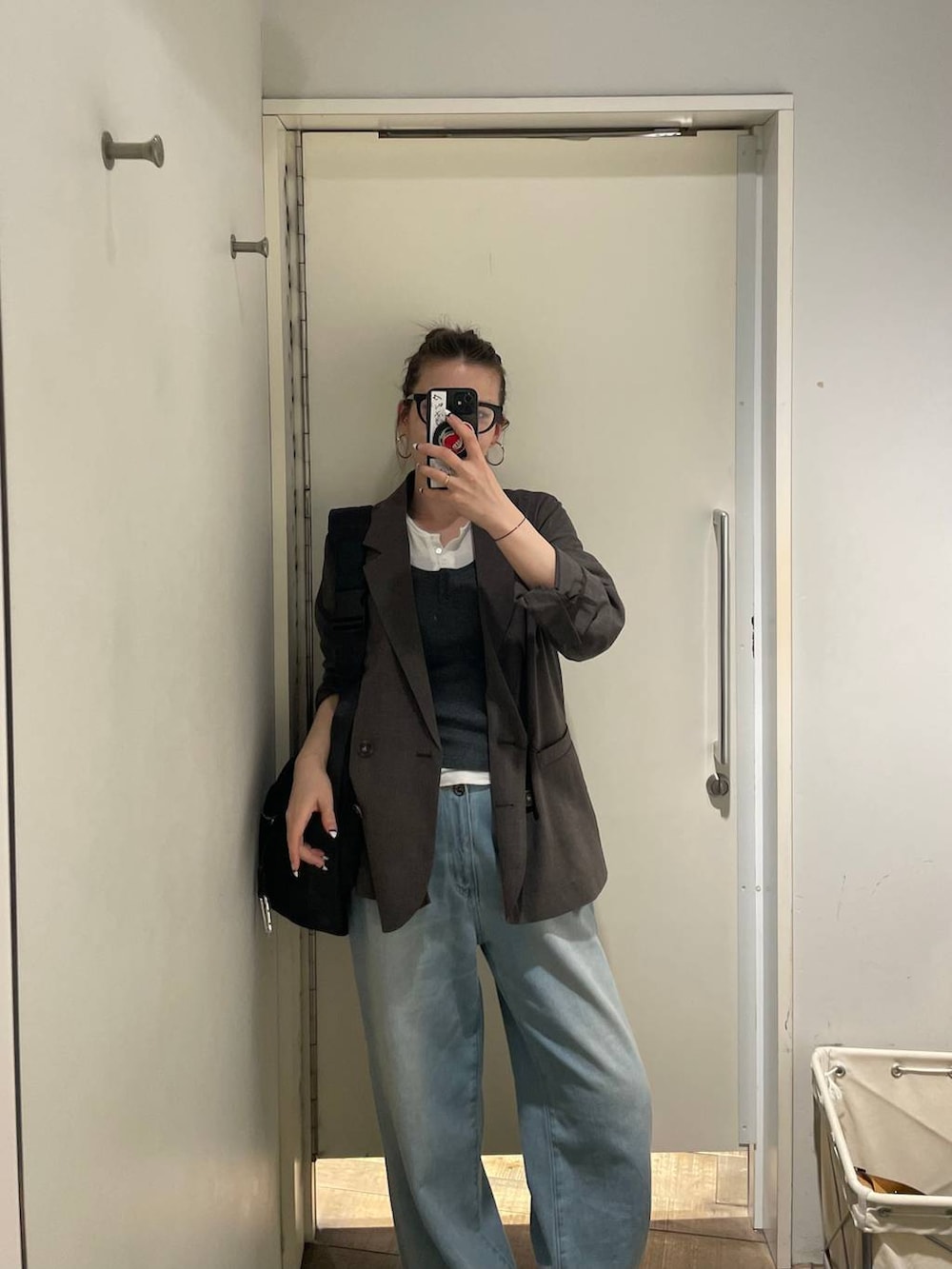 ブラック系のショルダーバッグ、ホワイト系のTシャツ/カットソー、ブラック系のローファーを着用したレディースの春コーディネートの4枚目の写真