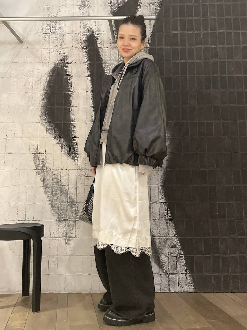 ブラック系のブルゾン、グレー系のパーカー、グレー系のデニムパンツを着用したレディースの冬コーディネートの2枚目の写真