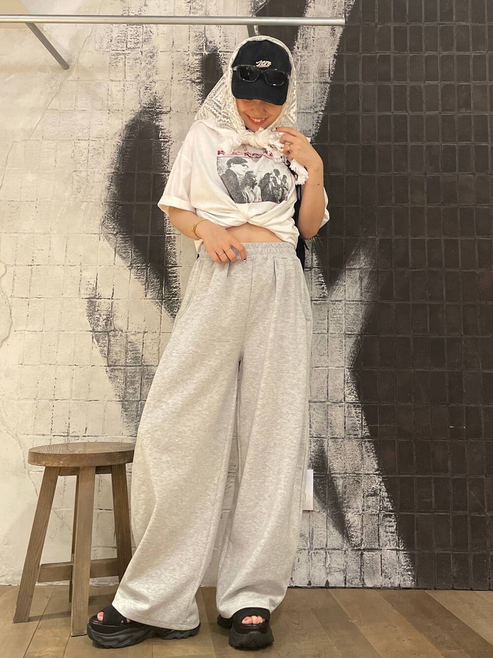 ブラック系のサンダル、ブラック系のショルダーバッグ、グレー系のスウェットパンツを着用したレディースの夏コーディネートの2枚目の写真