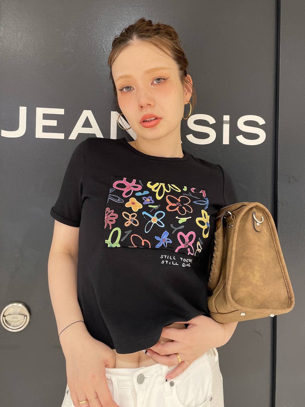 ブラック系のTシャツ/カットソー、ホワイト系のデニムパンツ、ブラウン系のボストンバッグを着用したレディースの夏コーディネートの2枚目の写真