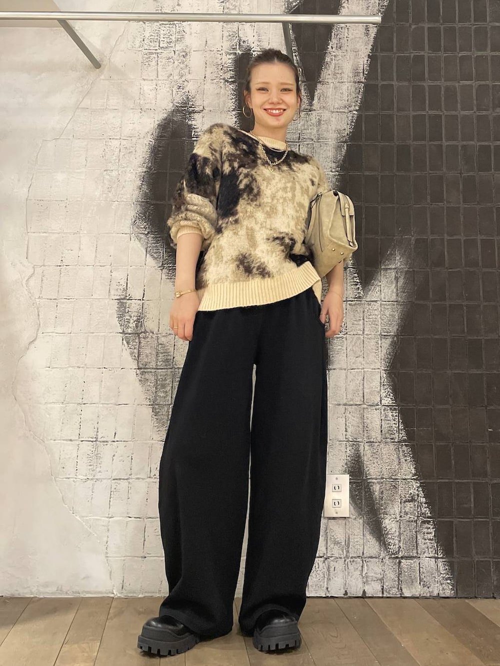 ブラウン系のニット/セーター、ベージュ系のボストンバッグ、ブラック系のブーツを着用したレディースの秋コーディネートの8枚目の写真