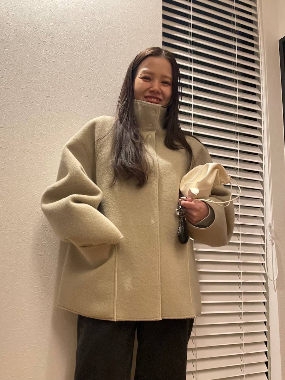 ベージュ系のブルゾン、ゴールド系のピアス（両耳用）を着用したレディースの冬コーディネートの4枚目の写真