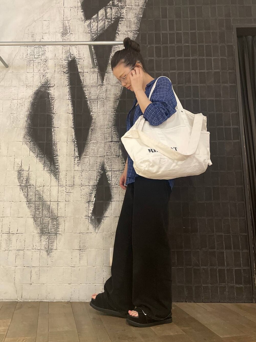 ブラック系のデニムパンツ、ブラック系のサンダル、ブルー系のシャツ/ブラウスを着用したレディースの春コーディネートの6枚目の写真