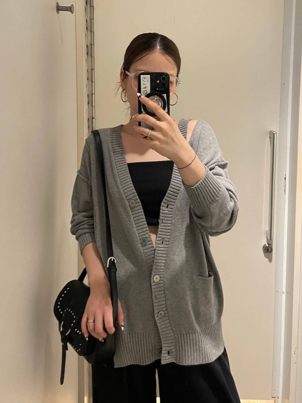 ブラック系のショルダーバッグ、ブラック系のモカシン/デッキシューズ、グレー系のカーディガン/ボレロを着用したレディースの秋コーディネートの3枚目の写真
