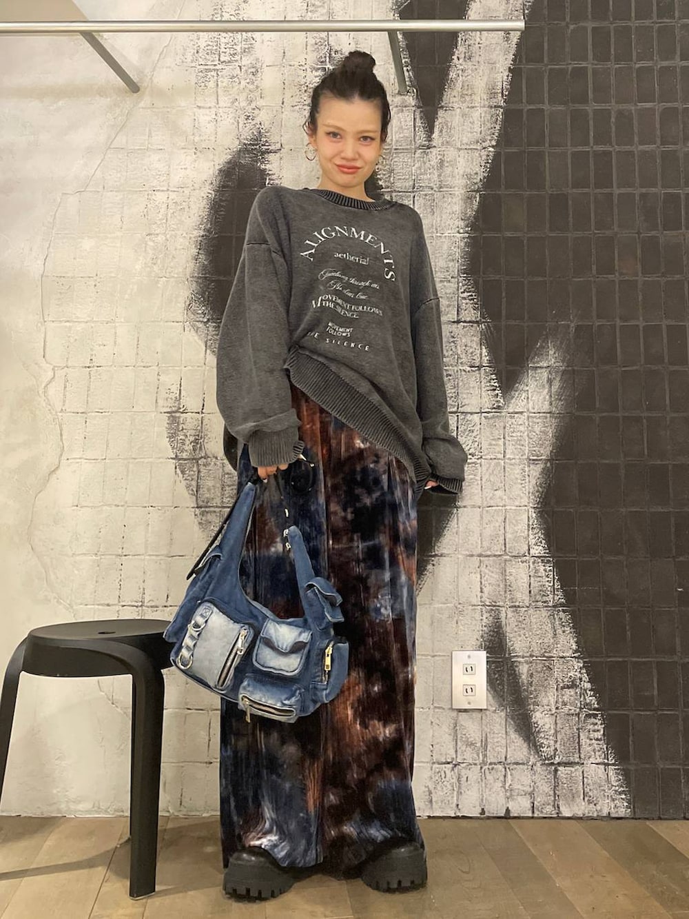 ブルー系のショルダーバッグ、ブラック系のブーツ、ブラウン系のその他パンツを着用したレディースの秋コーディネートの2枚目の写真