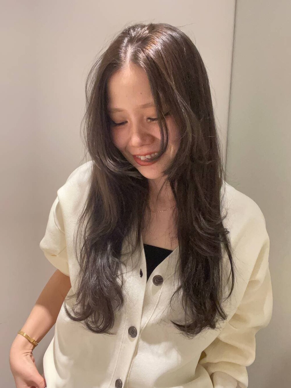 グレー系のデニムパンツ、ホワイト系のカーディガン/ボレロを着用したレディースの秋コーディネートの3枚目の写真