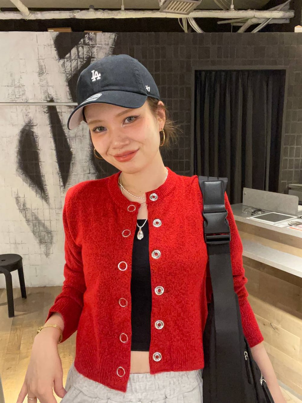 ブラック系のショルダーバッグ、ブラック系のブーツ、グレー系のスウェットパンツを着用したレディースの秋コーディネートの8枚目の写真