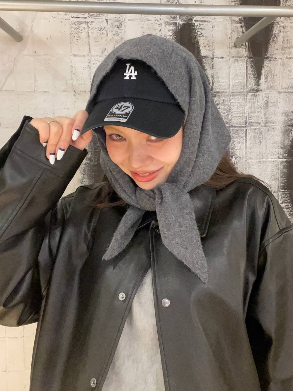 ブラック系のショルダーバッグ、グレー系のデニムパンツ、ブラック系のライダースジャケットを着用したレディースの秋コーディネートの2枚目の写真