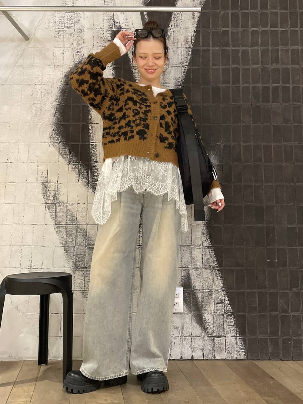 ブラック系のショルダーバッグ、ブルー系のデニムパンツ、ブラック系のブーツを着用したレディースの冬コーディネートの5枚目の写真