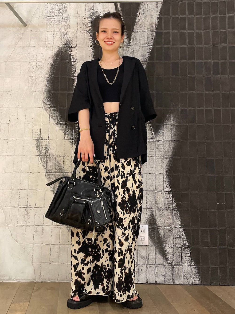 ブラック系のタンクトップ、ブラック系のボストンバッグ、ブラック系のサンダルを着用したレディースの夏コーディネートの8枚目の写真