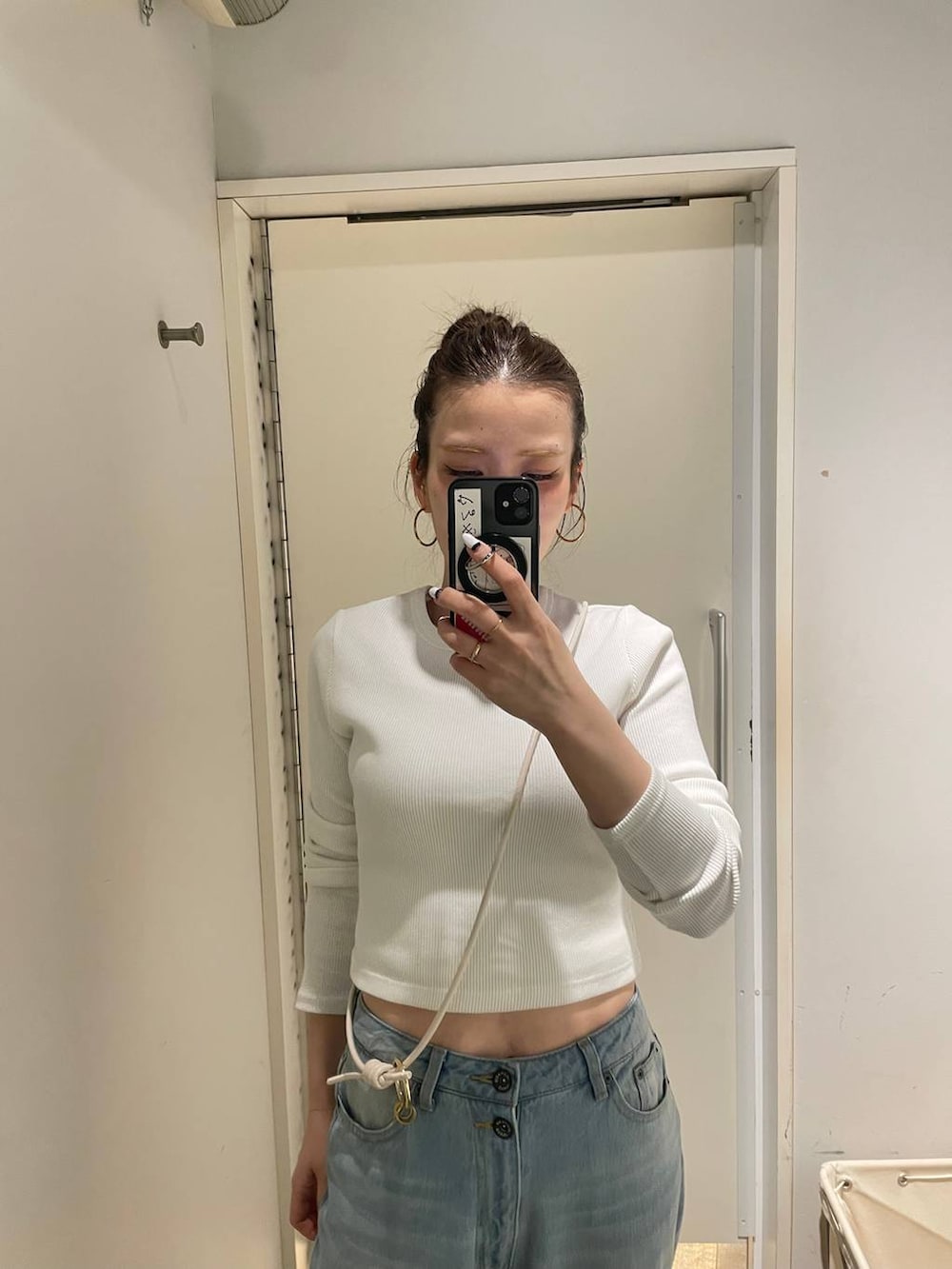 グリーン系のトートバッグ、ブルー系のデニムパンツ、ホワイト系のTシャツ/カットソーを着用したレディースの春コーディネートの4枚目の写真