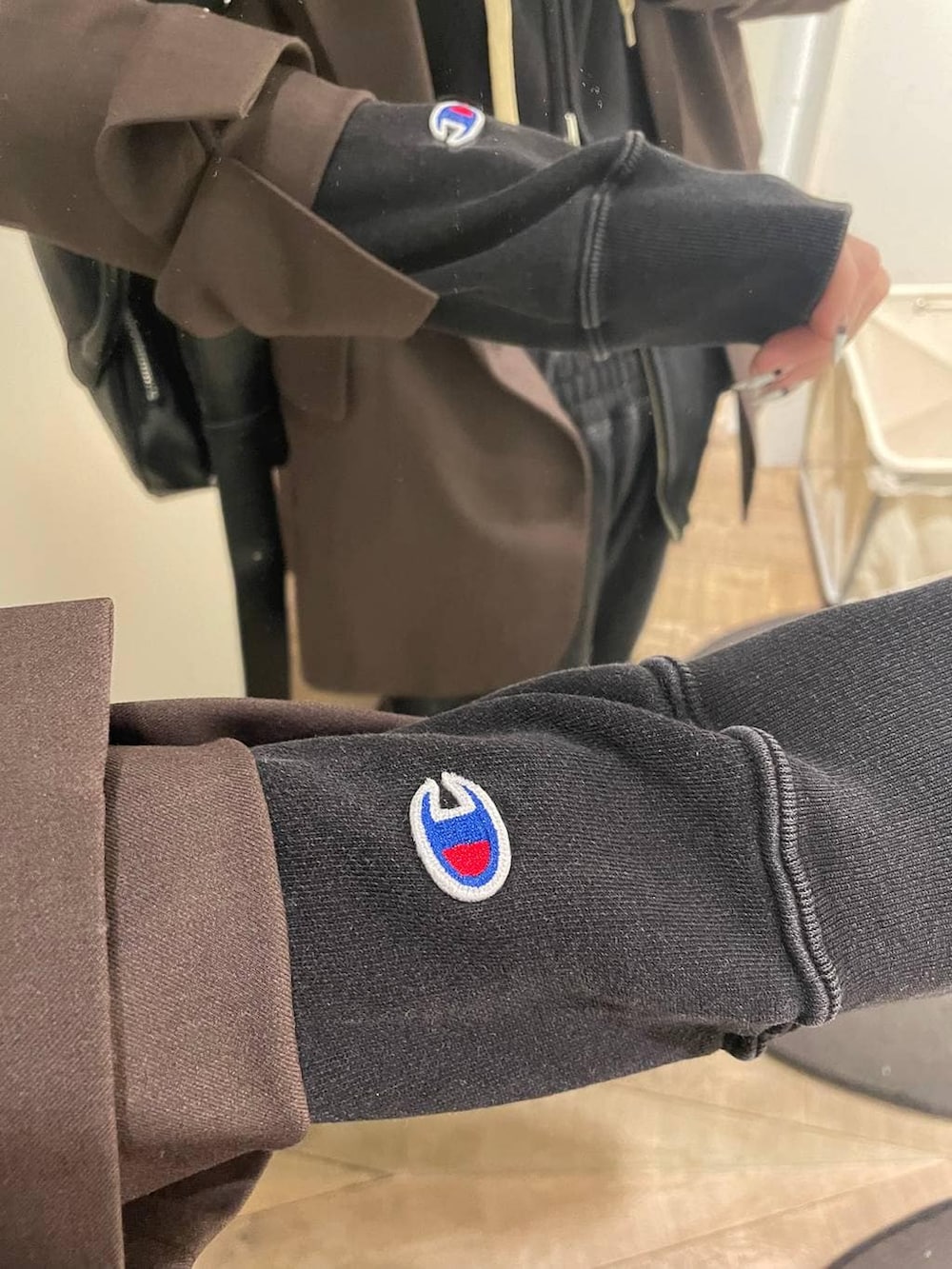 ブラック系のパーカー、ブラック系のスウェットパンツ、ホワイト系のキャミソールを着用したレディースの冬コーディネートの3枚目の写真