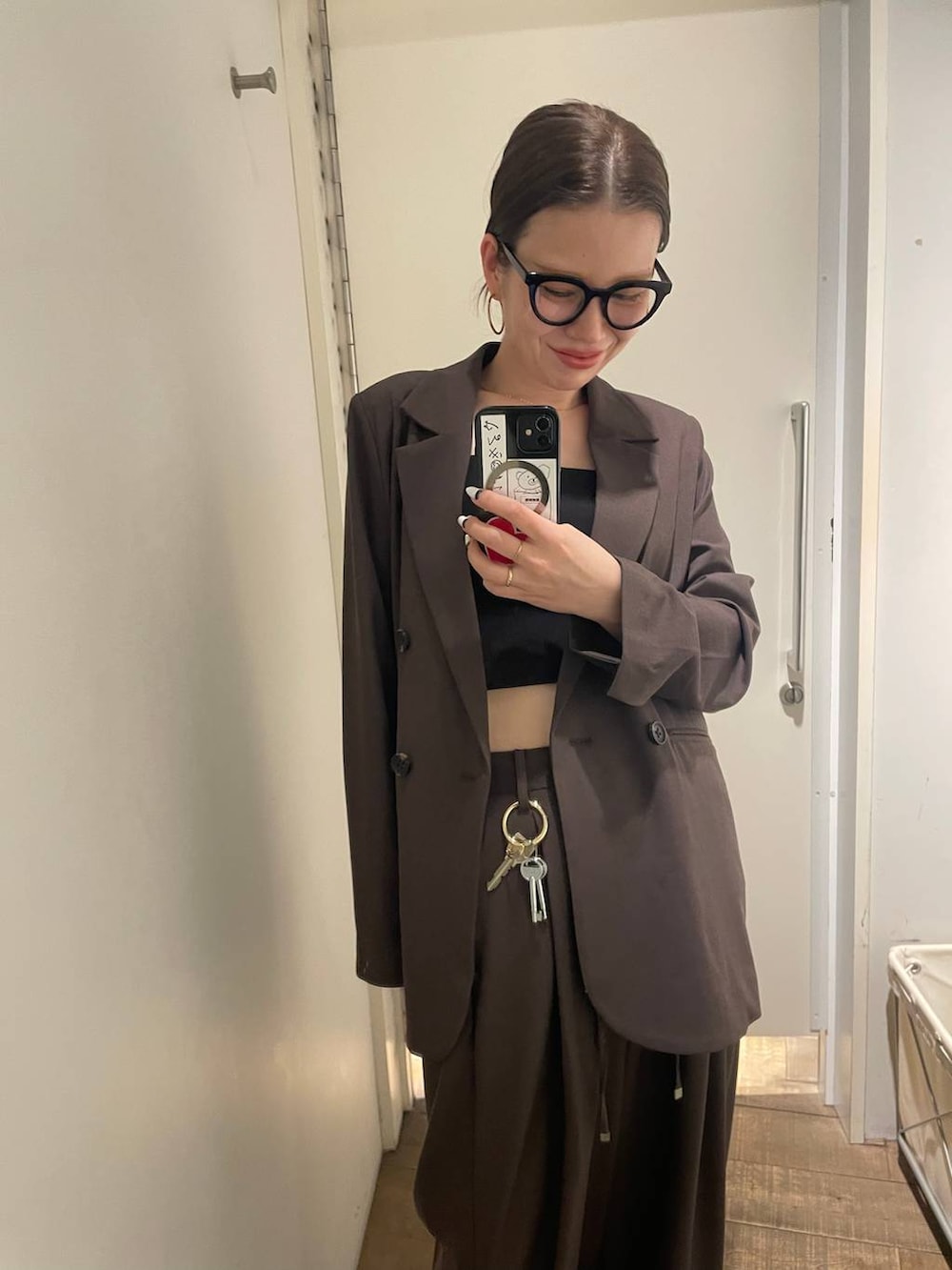 ブラウン系のテーラードジャケット、ブラック系のボストンバッグ、ブラウン系のスラックスを着用したレディースの冬コーディネートの5枚目の写真