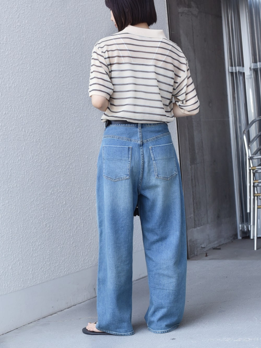 ブルー系のデニムパンツ、ベージュ系のニット/セーターを着用したレディースの夏コーディネートの2枚目の写真