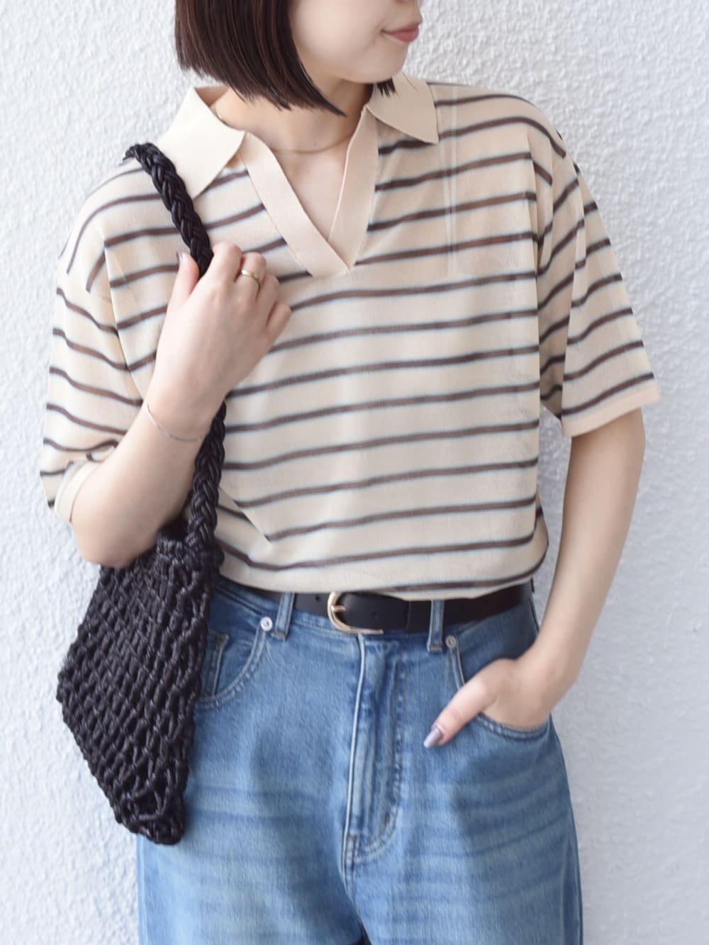 ブルー系のデニムパンツ、ベージュ系のニット/セーターを着用したレディースの夏コーディネートの3枚目の写真