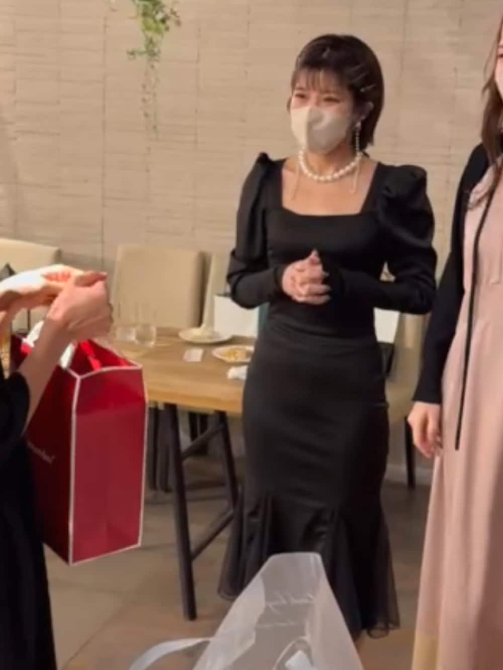 ブラック系のパンプス、ブラック系のショルダーバッグを着用したレディースの冬コーディネートの2枚目の写真