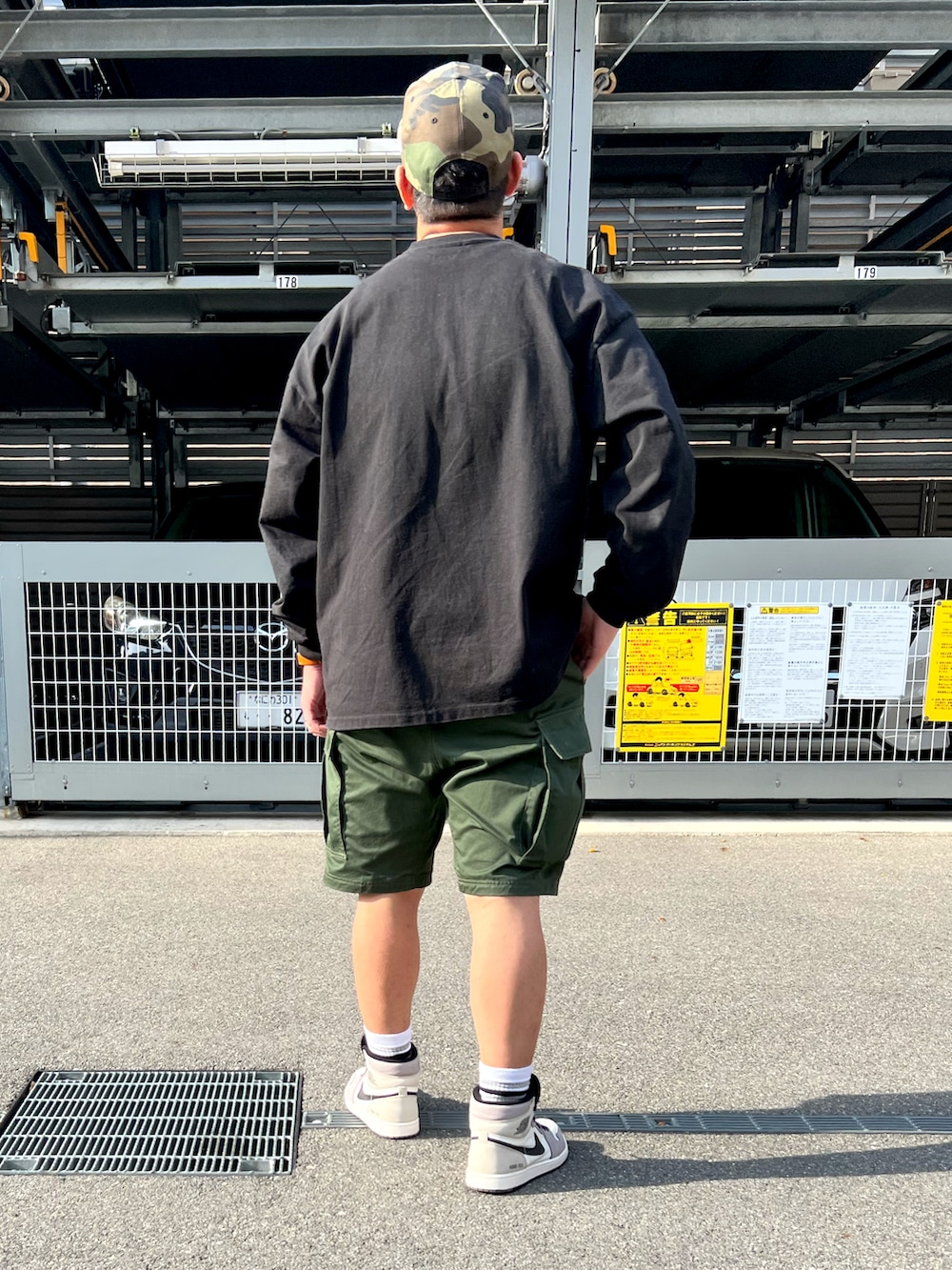 ブラック系のTシャツ/カットソー、グリーン系のカーゴパンツ、グレー系のスニーカーを着用したメンズの春コーディネートの3枚目の写真