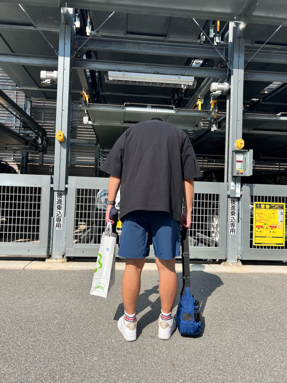 ブルー系のショルダーバッグ、ホワイト系のスニーカー、ブルー系のその他パンツを着用したメンズの秋コーディネートの2枚目の写真