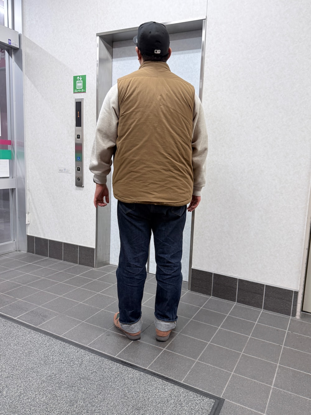 グレー系のスウェット、ベージュ系のその他アウター、ブラウン系のスニーカーを着用したメンズの冬コーディネートの2枚目の写真