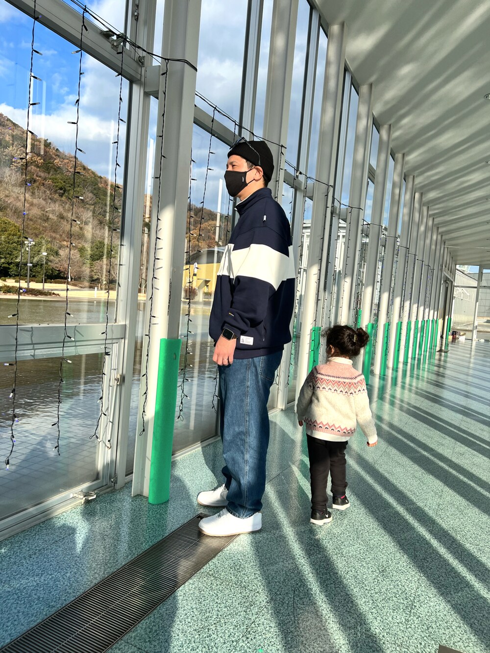 ホワイト系のスニーカー、ブルー系のデニムパンツ、ブルー系のスウェットを着用したメンズの冬コーディネートの3枚目の写真
