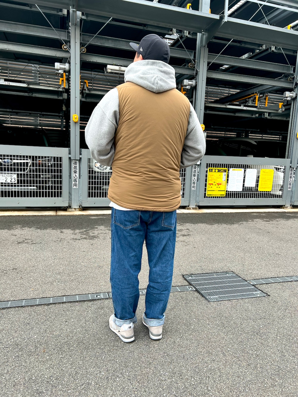 グレー系のスニーカー、ブルー系のデニムパンツ、グレー系のパーカーを着用したメンズの冬コーディネートの2枚目の写真