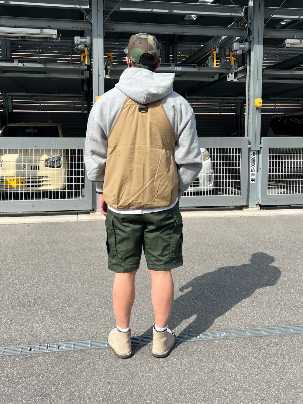 グリーン系のカーゴパンツ、ベージュ系のブーツ、グレー系のパーカーを着用したメンズの春コーディネートの2枚目の写真