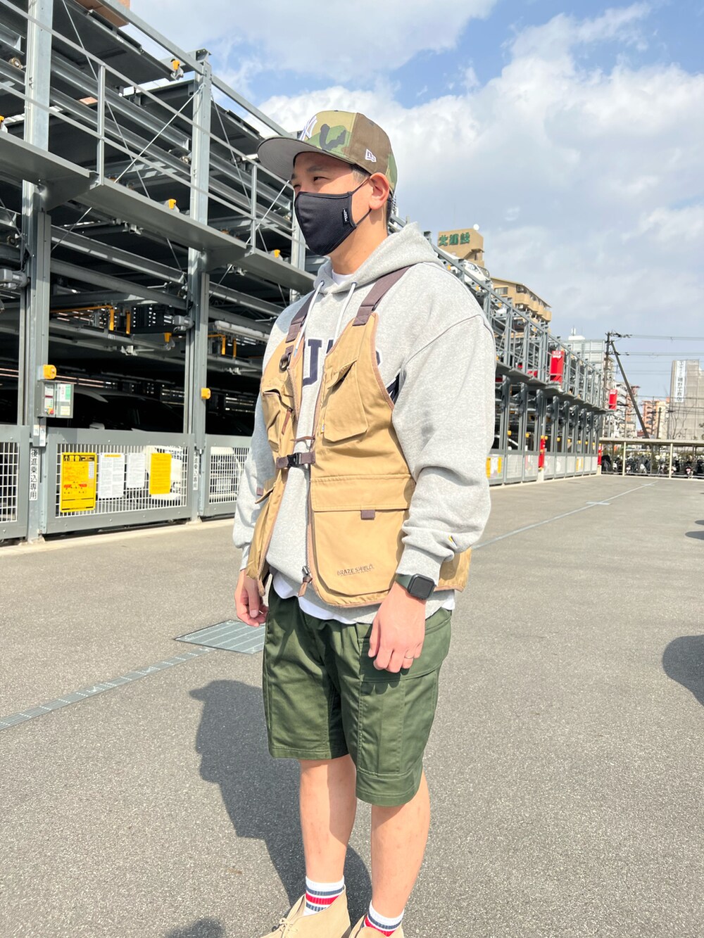 グリーン系のカーゴパンツ、ベージュ系のブーツ、グレー系のパーカーを着用したメンズの春コーディネートの3枚目の写真