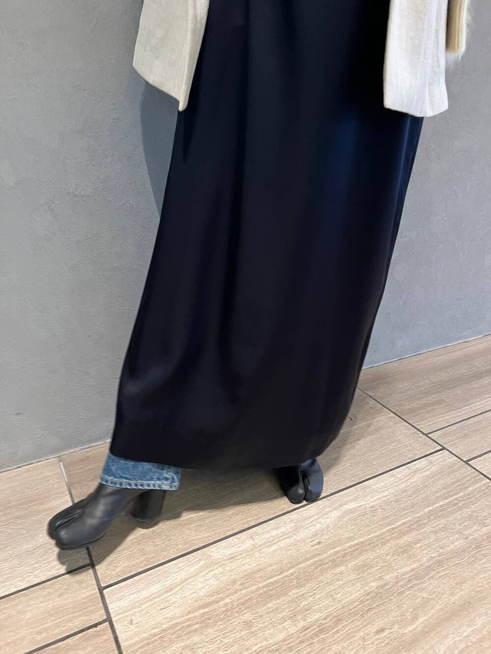 ブルー系のワンピース、ブルー系のデニムパンツ、ベージュ系のテーラードジャケットを着用したレディースの秋コーディネートの5枚目の写真