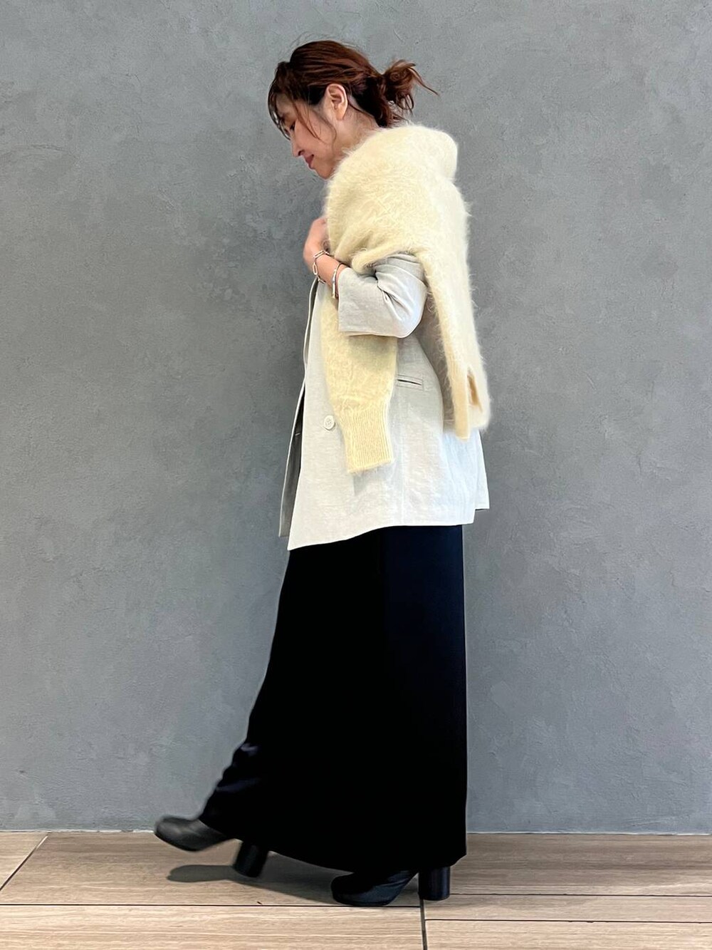 ブルー系のワンピース、ブルー系のデニムパンツ、ベージュ系のテーラードジャケットを着用したレディースの秋コーディネートの2枚目の写真
