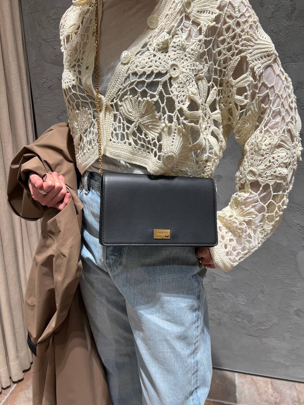 ホワイト系のTシャツ/カットソー、ブルー系のデニムパンツ、ベージュ系のトレンチコートを着用したレディースの冬コーディネートの8枚目の写真