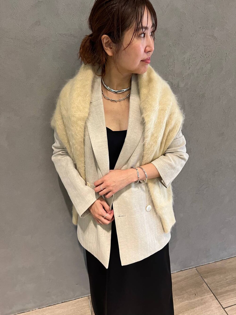 ブルー系のワンピース、ブルー系のデニムパンツ、ベージュ系のテーラードジャケットを着用したレディースの秋コーディネートの4枚目の写真