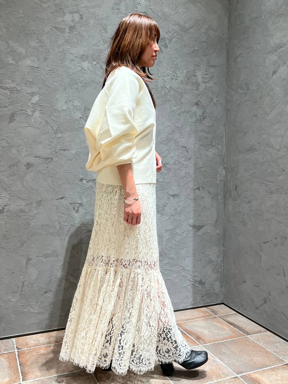 ホワイト系のスカート、ホワイト系のカーディガン/ボレロを着用したレディースの冬コーディネートの2枚目の写真