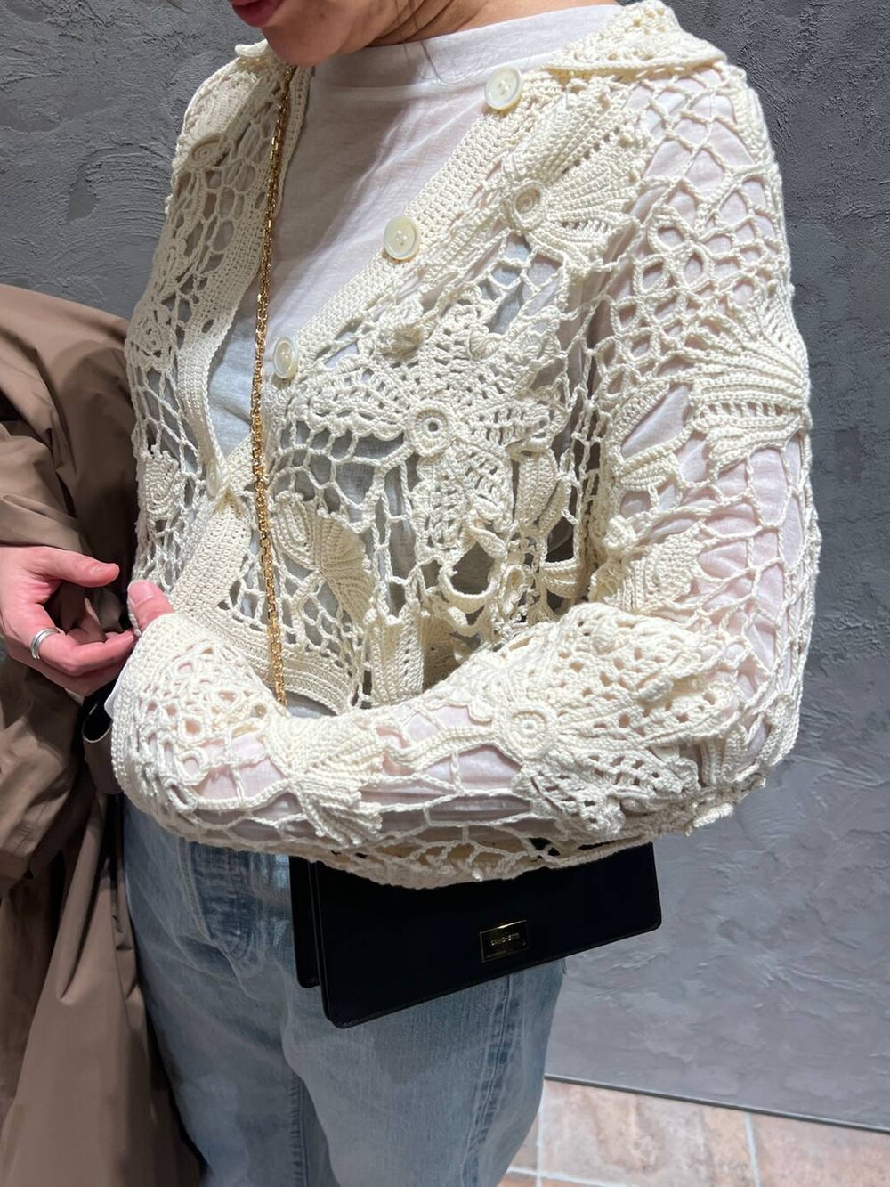 ホワイト系のTシャツ/カットソー、ブルー系のデニムパンツ、ベージュ系のトレンチコートを着用したレディースの冬コーディネートの6枚目の写真
